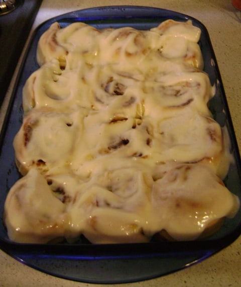 alton brown's overnight cinnamon rolls, coated with glaze in the pan