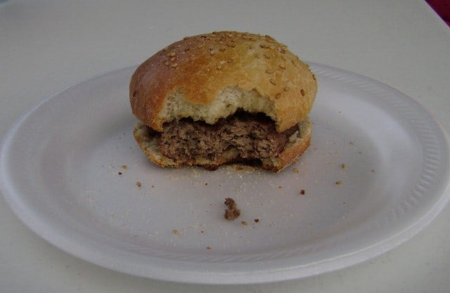homemade hamburger bun, with a hamburger on it, with a few bites taken out of it