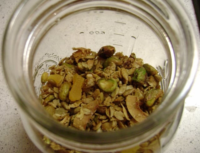 olive oil granola with dried apricots and pistachios, in a glass mason jar