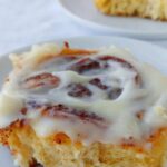 cinnamon rolls with cream cheese glaze, on plates, in a row