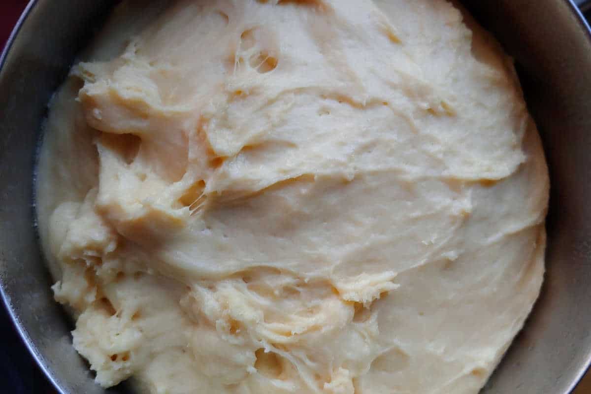 dough for cinnamon rolls with cream cheese glaze, in a bowl, after rising