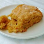 apple and pear scone, on a plate, with a piece broken off