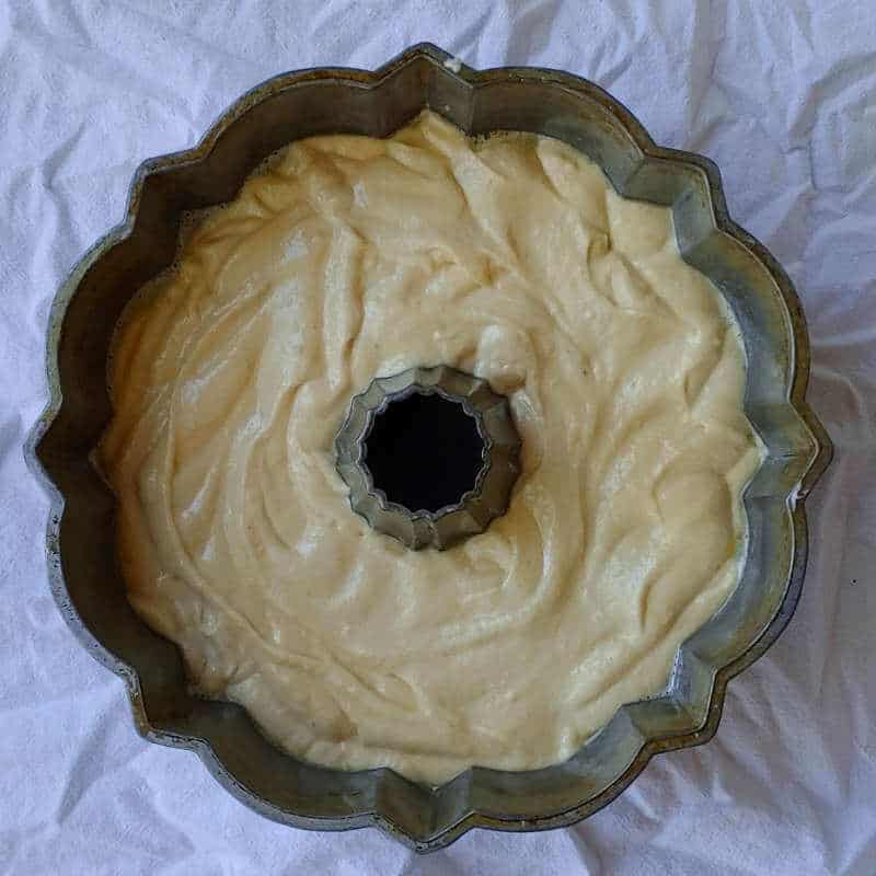 batter for apple cider donut cake, in a bundt cake pan