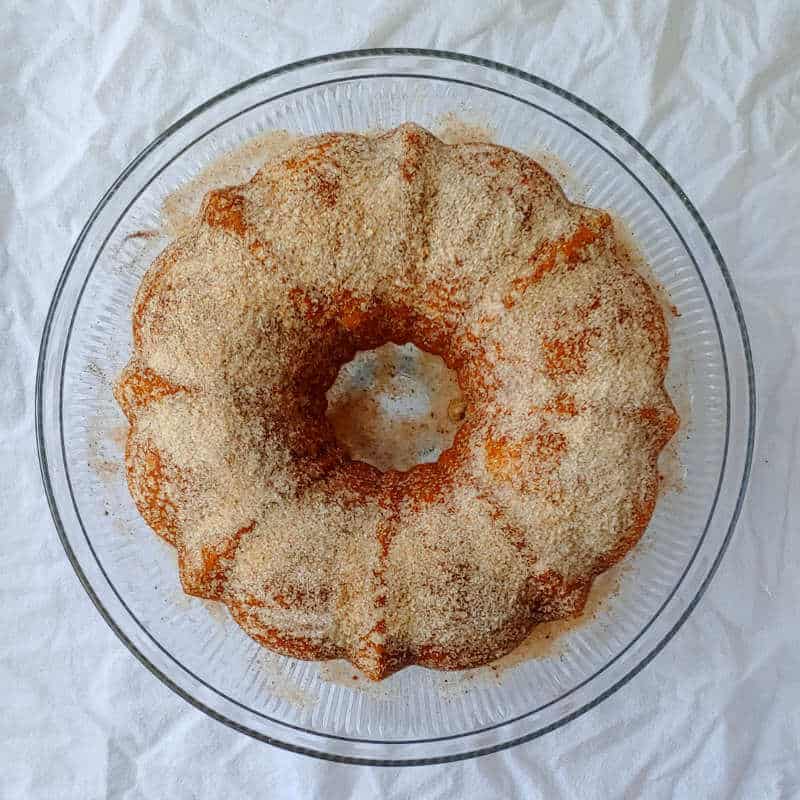 apple cider donut cake, turned out from a bundt pan and sprinkled with cinnamon sugar, seen from overhead