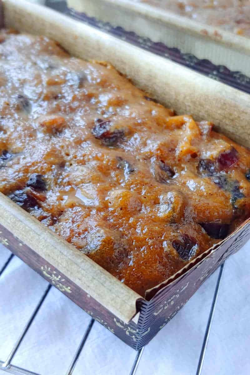a mini loaf of Alton Brown's fruitcake, in a brown paper loaf pan