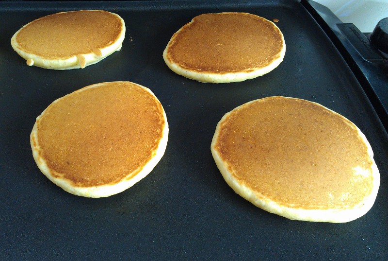 lemon cornmeal pancakes, cooking on a griddle