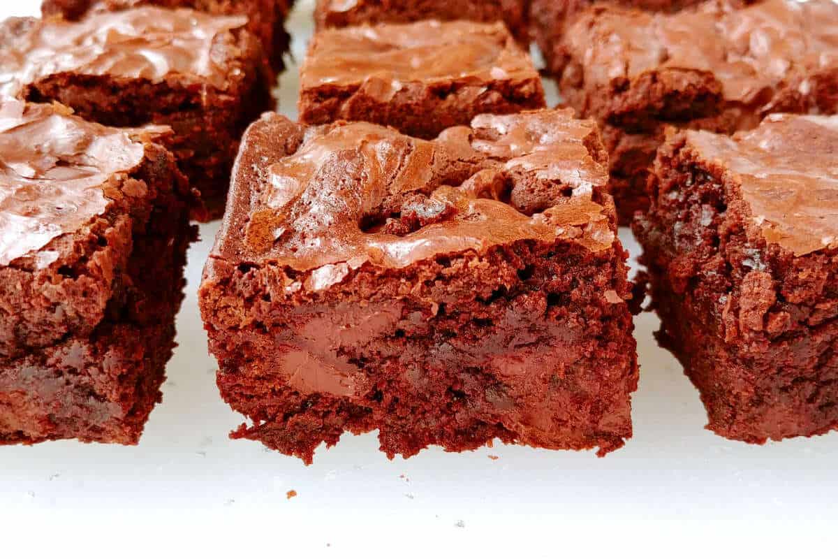 fudge brownies, lined up in rows, cut to see the moist crumbs