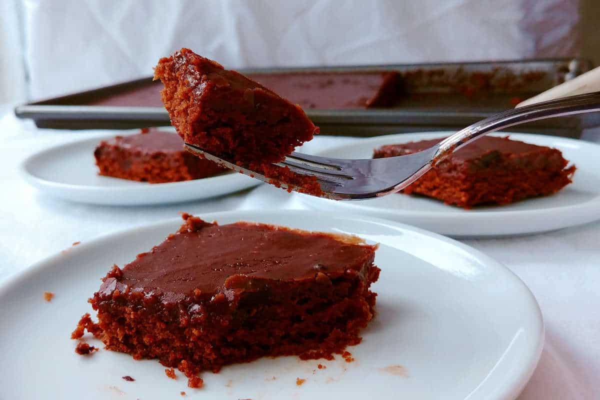 chocolate sheet cake on plates, with a bite on a fork