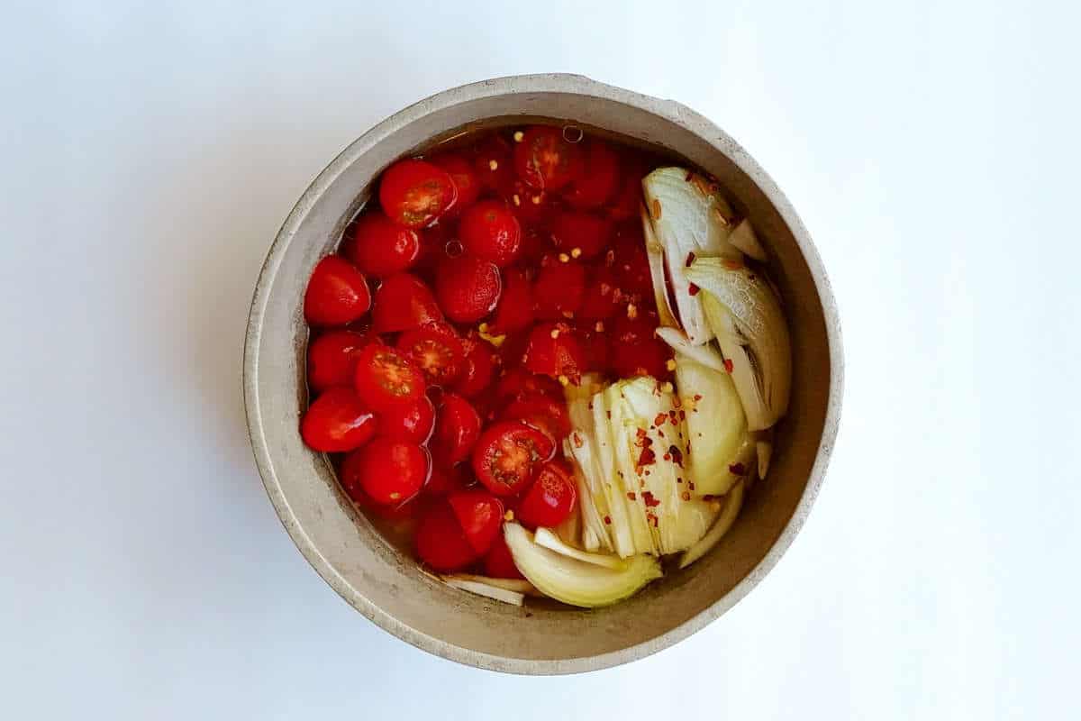 farro with tomatoes, ingredients (including tomatoes and onions) in a pot