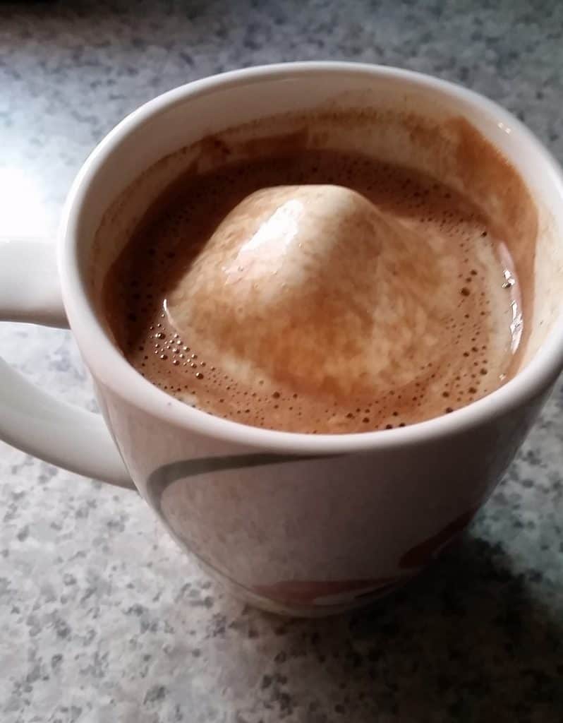 decadent hot chocolate mix, mixed in milk in a mug, with a marshmallow