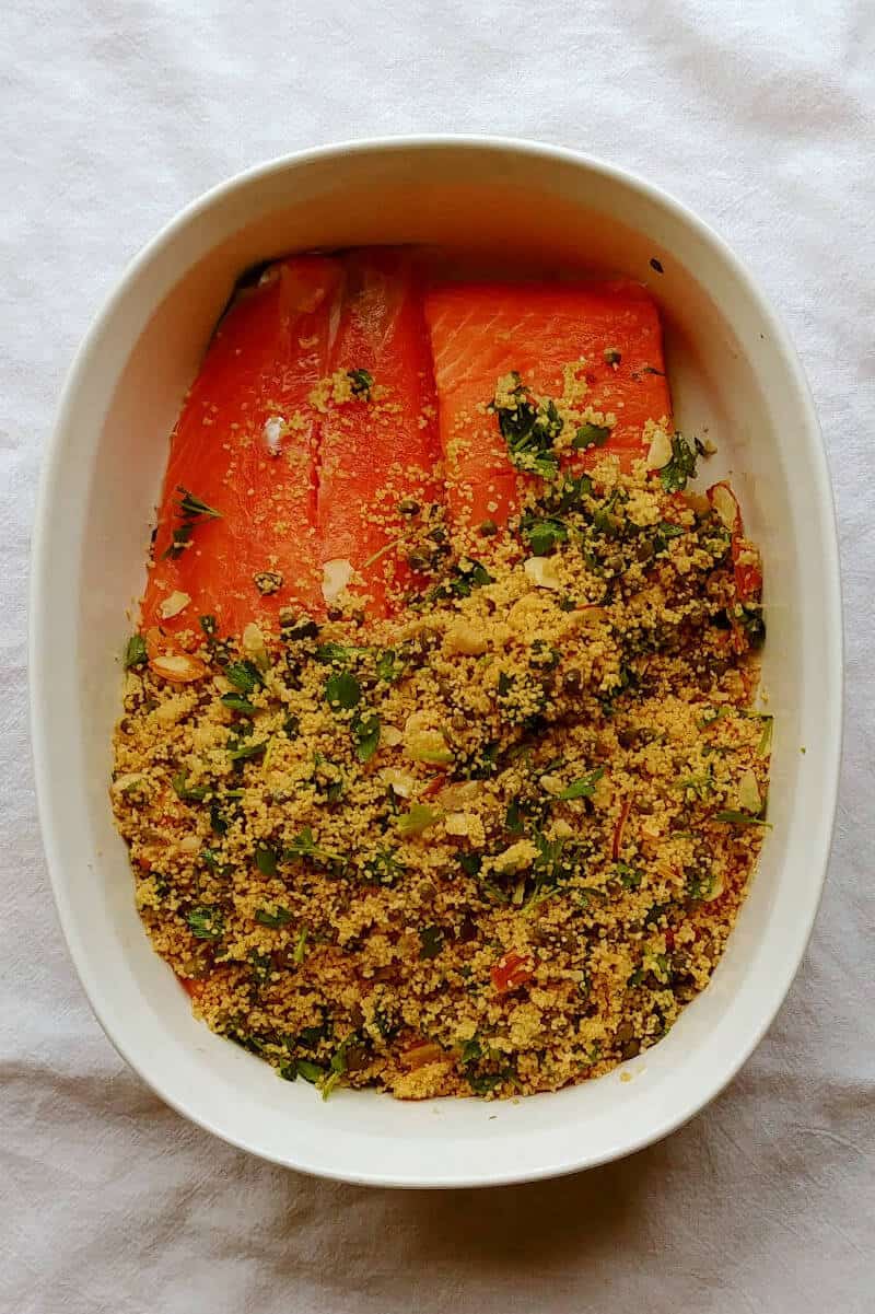 salmon with baked couscous, with salmon only partially covered by the couscous before it bakes