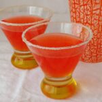two campari margaritas in glasses lined with sugar