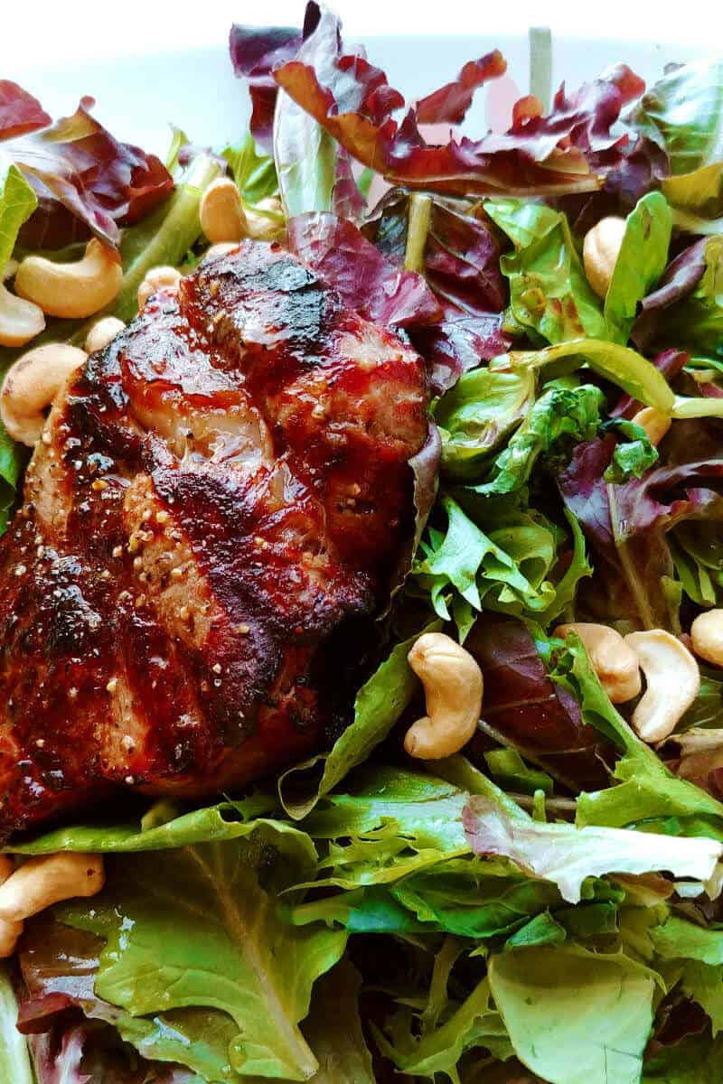 steak salad with lime and sesame dressing, topped with cashews, close-up