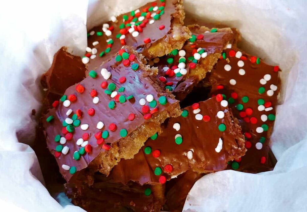 chocolate toffee cracker cookies with christmas sprinkles, in a bowl