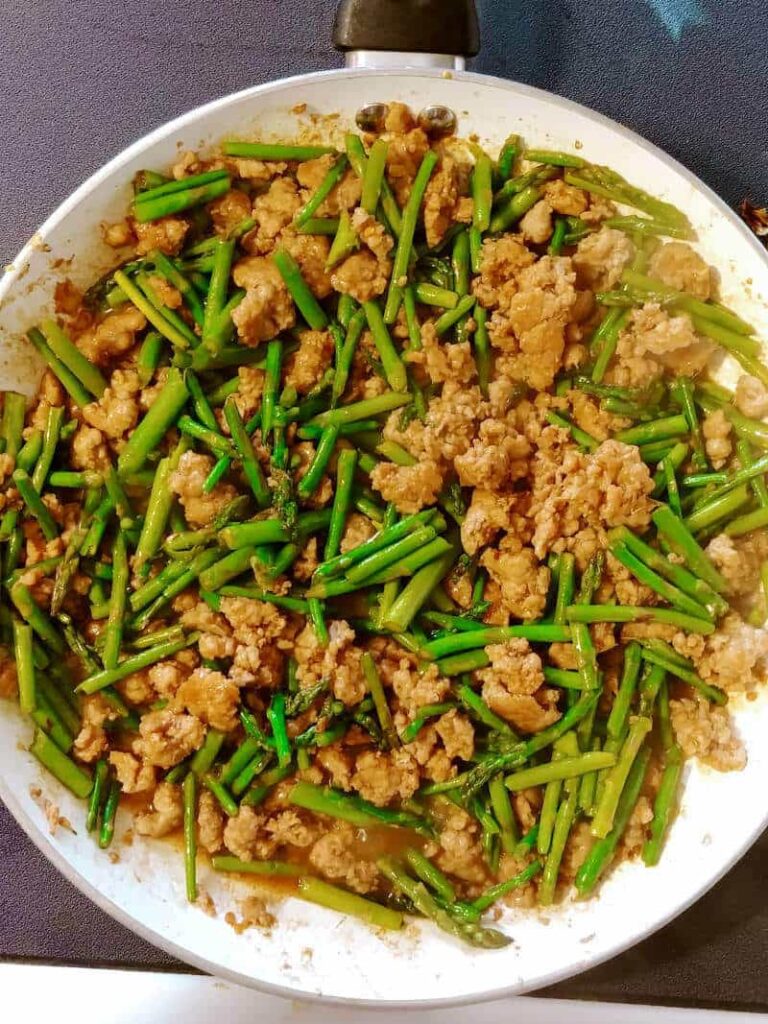 spicy pork with asparagus, in a skillet