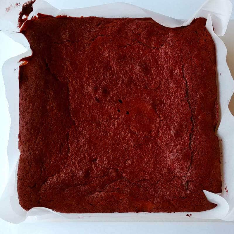 alton brown's plain ole' brownies, in a square metal pan with parchment paper