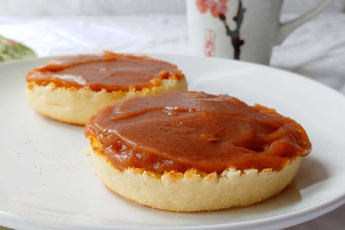 slow cooker apple butter with no sugar added, on English Muffins, on a plate