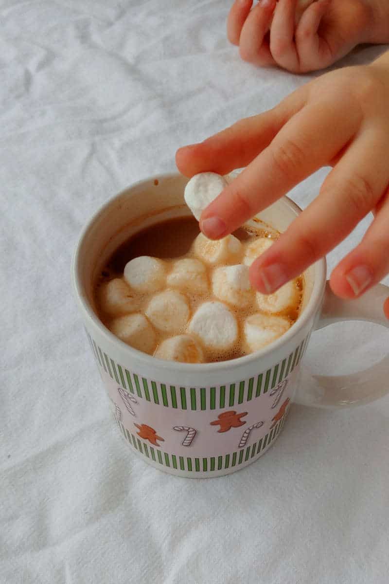 placing mini marshmallows in a mug of hot cocoa made with Alton Brown's Hot Cocoa Mix