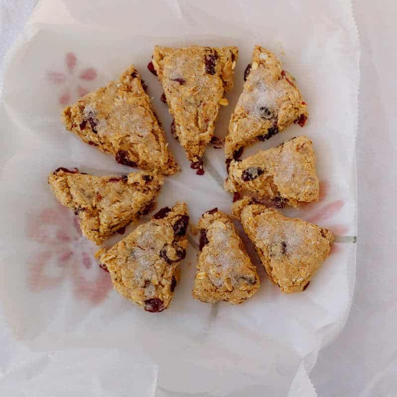 cranberry oat pecan scones, cut into wedges, placed on waxed paper on a plate, and frozen