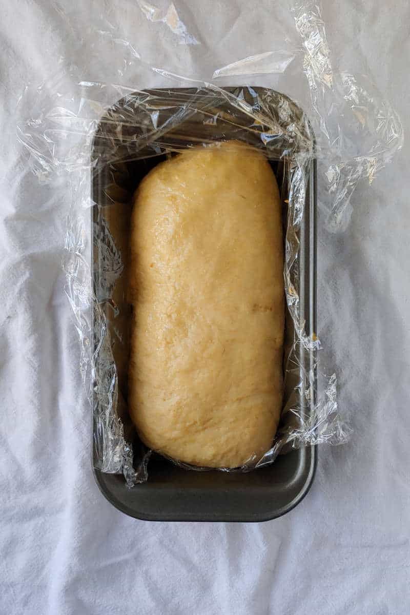 dough for yeasted banana sandwich bread, in a plastic wrap lined loaf pan, ready to go into the freezer