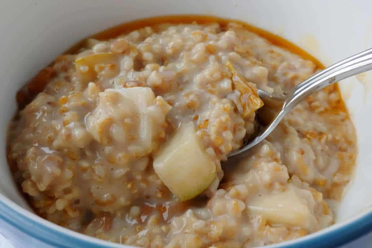 steel-cut oats with walnuts and pear, in a bowl, with a spoon and honey