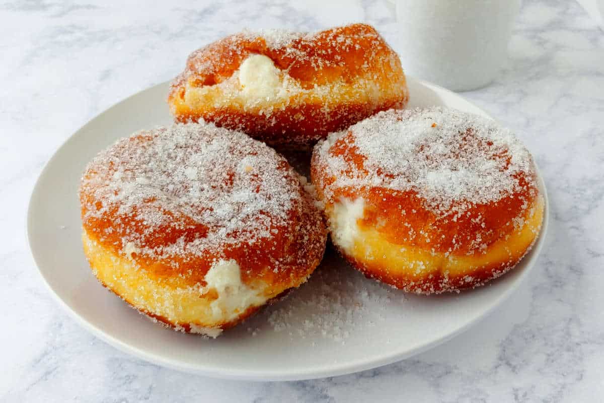 3 paczkis on a plate, coated with sugar