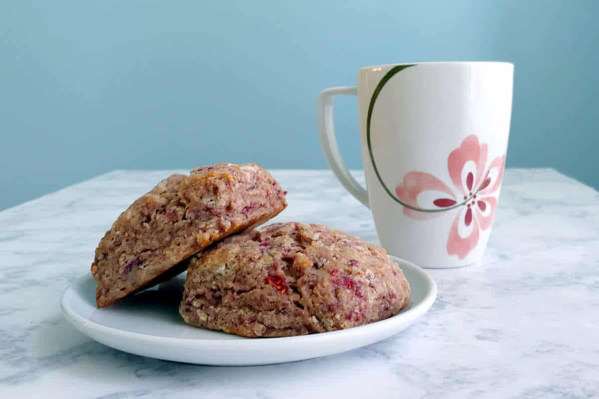 whole wheat raspberry ricotta scones, on a plate, with a mug