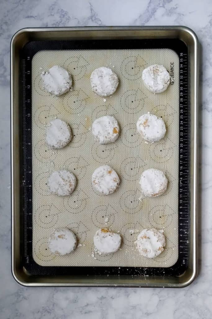 gooey butter cookie dough balls, flattened on a baking sheet