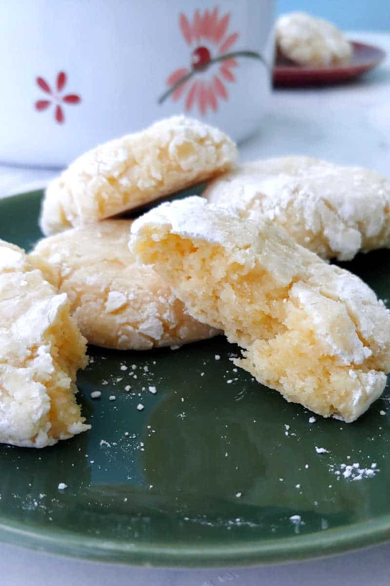 a gooey butter cookie, broken apart to show texture, on a green plate