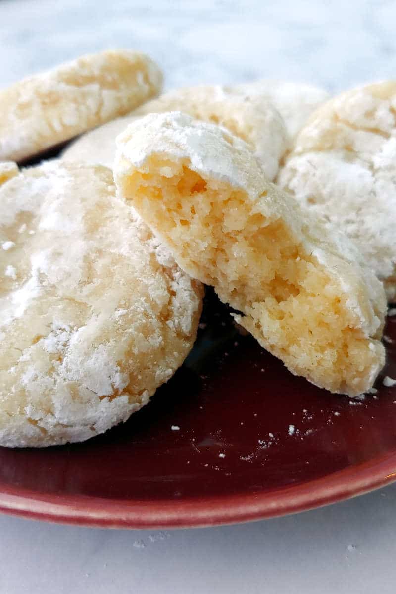 a gooey butter cookie, broken apart to show texture, on a red plate