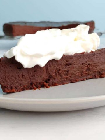 a slice of chocolate truffle cake, with whipped cream on top
