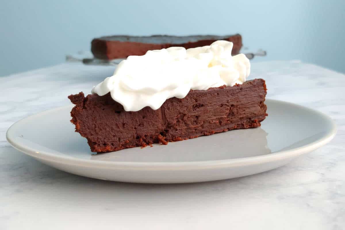 a slice of chocolate truffle cake, with whipped cream on top