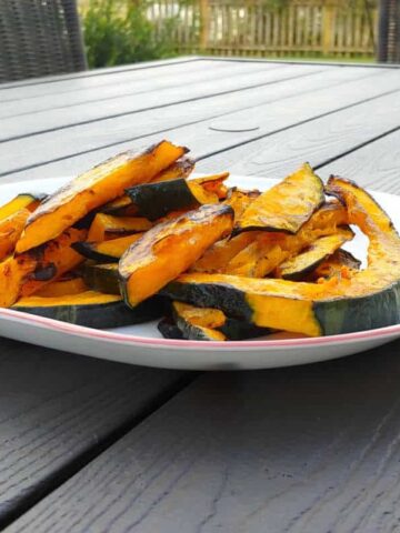 slices of grilled winter squash, on a plate outside