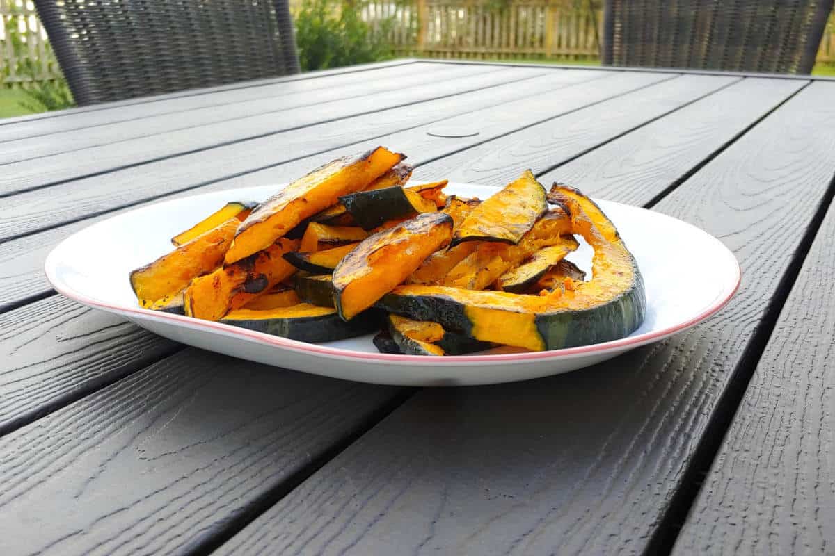 slices of grilled winter squash, on a plate outside