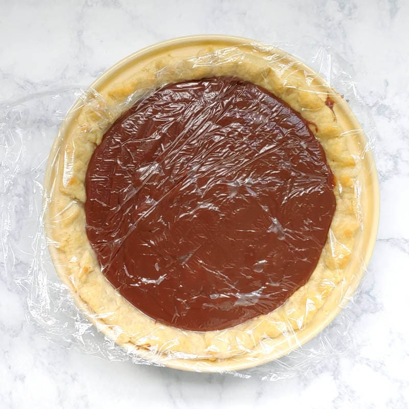 chocolate pie filling covered with plastic wrap