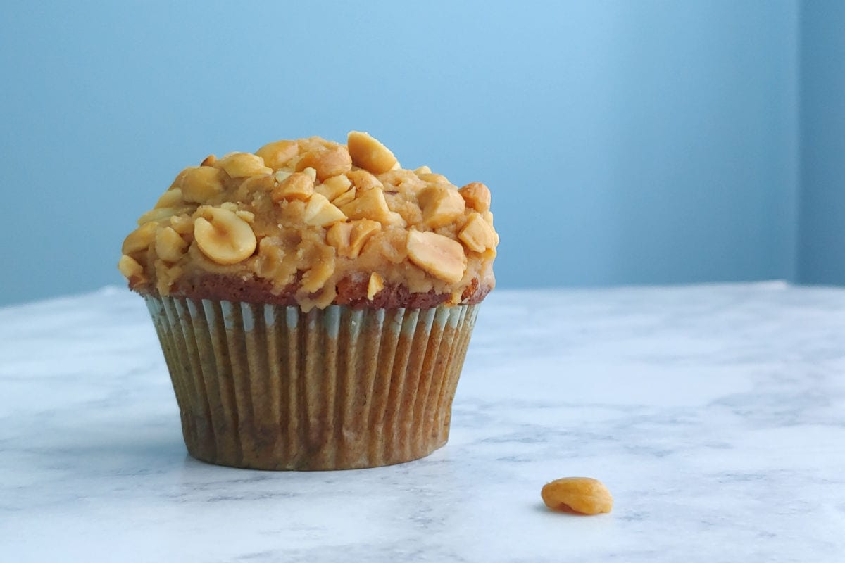 a banana cupcake with peanut butter frosting, topped with peanuts