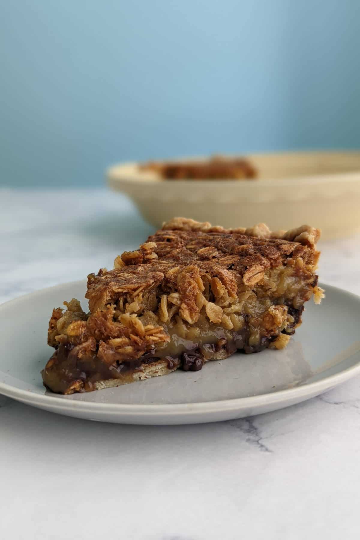 black bottom oatmeal pie slice, in front of pie dish