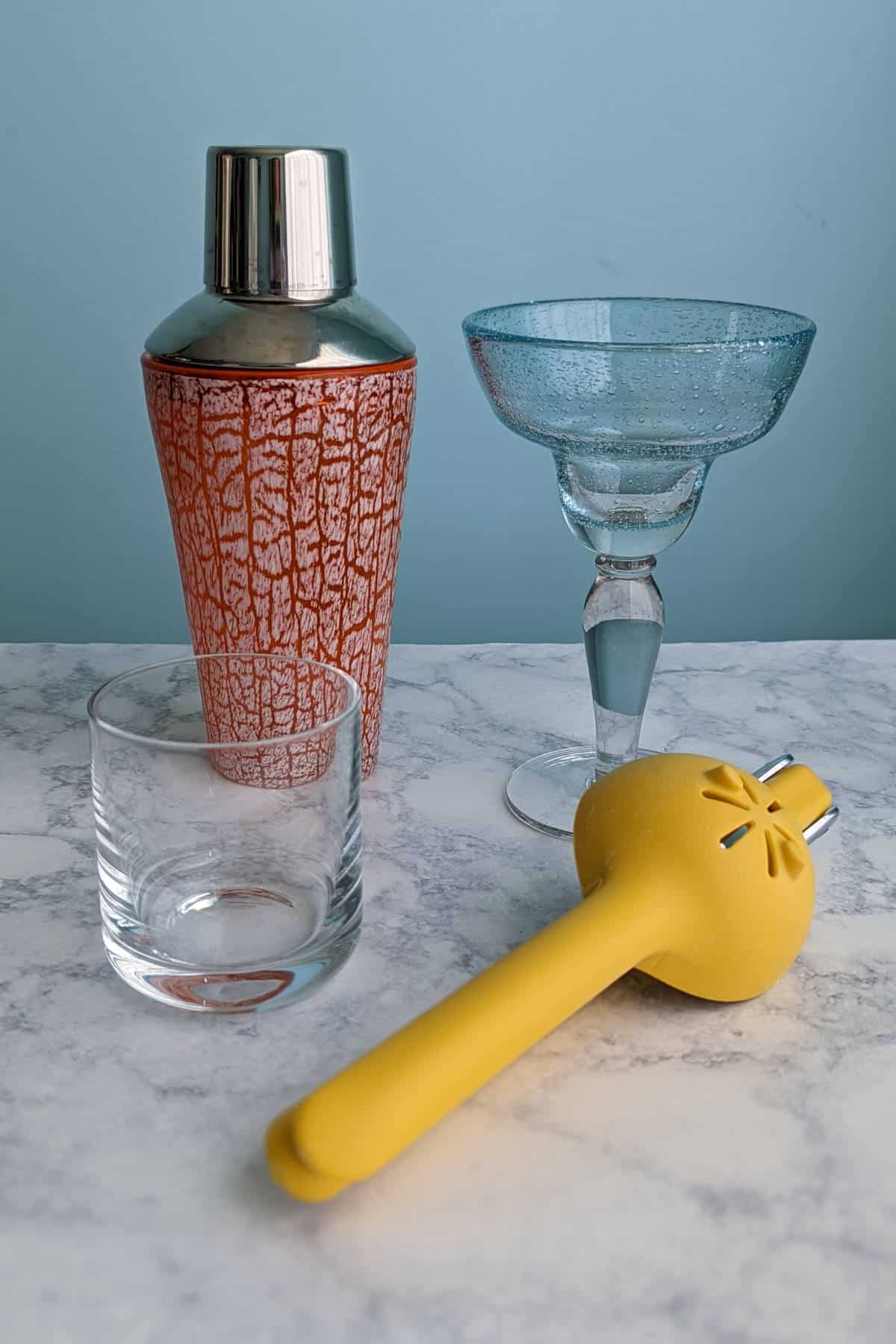 cocktail shaker, margarita glass, short glass, and citrus juicer