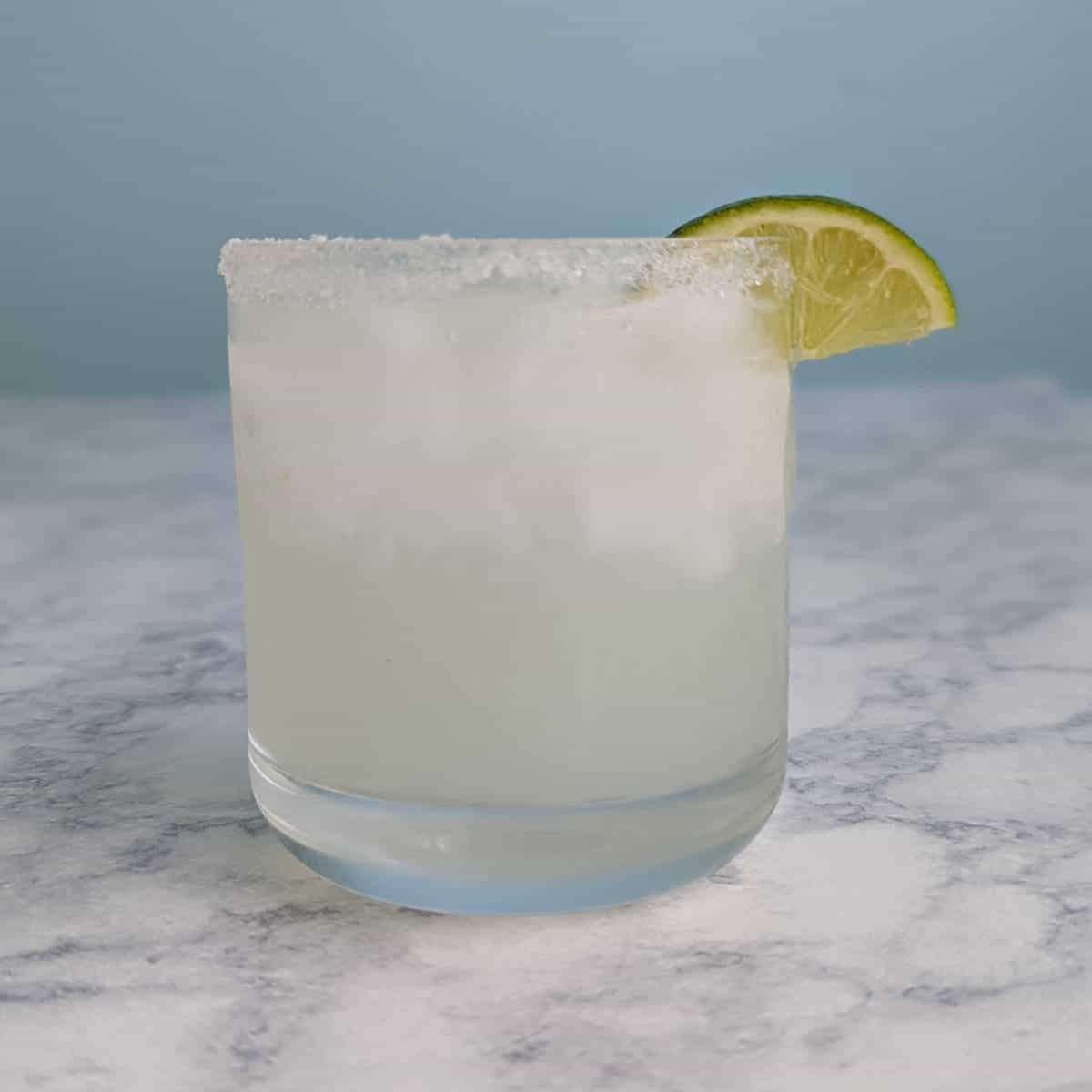margarita in glass with lime garnish, square image