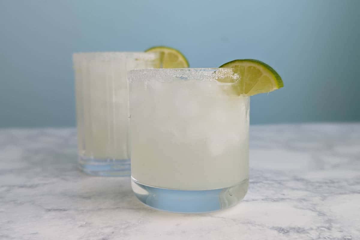 2 margaritas in glasses with lime garnish
