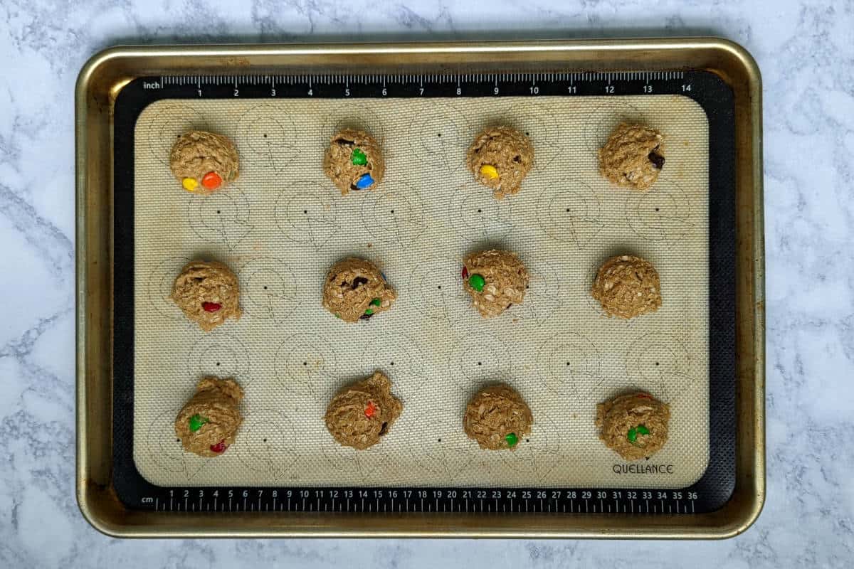 balls of monster cookie dough, on a baking sheet before baking