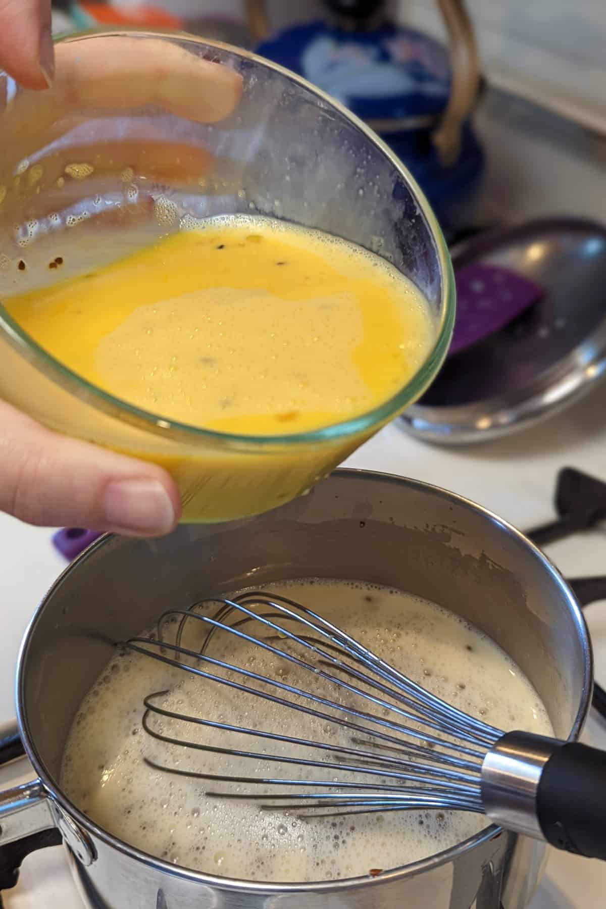 pouring eggs into hot milk mixture