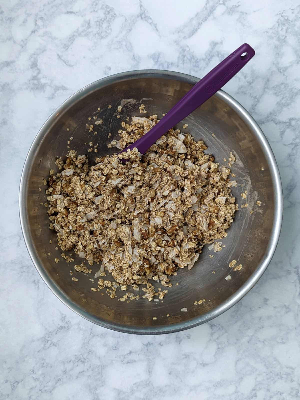 dry ingredients for granola mixed into the wet ingredients