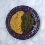 saag (Indian creamed spinach) and dal (Indian lentils) over rice, on a plate - square image