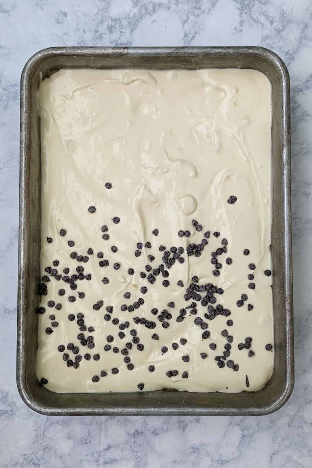chocolate chip cookie cheesecake bars, in pan before baking