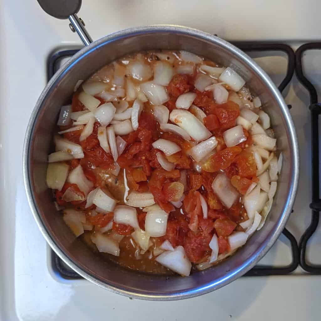 onion, tomato, and mustard seeds, frying in a pot