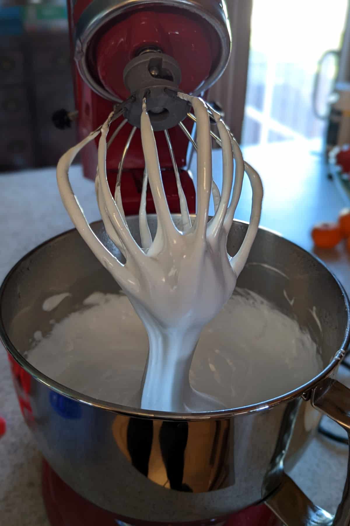 marshmallow fluff pouring from whisk attachment of stand mixer