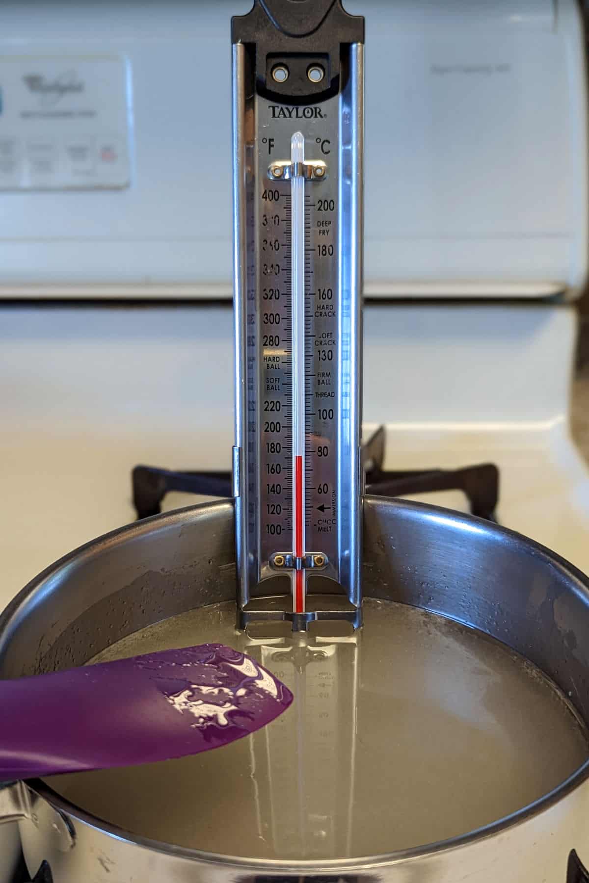 thermometer inserted into sugar syrup at beginning of cooking time
