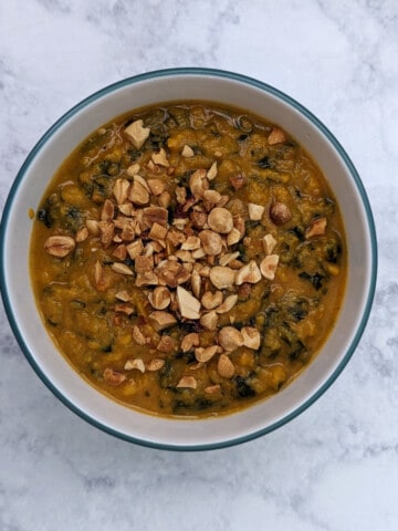 sweet potato peanut stew, in a bowl, topped with peanuts