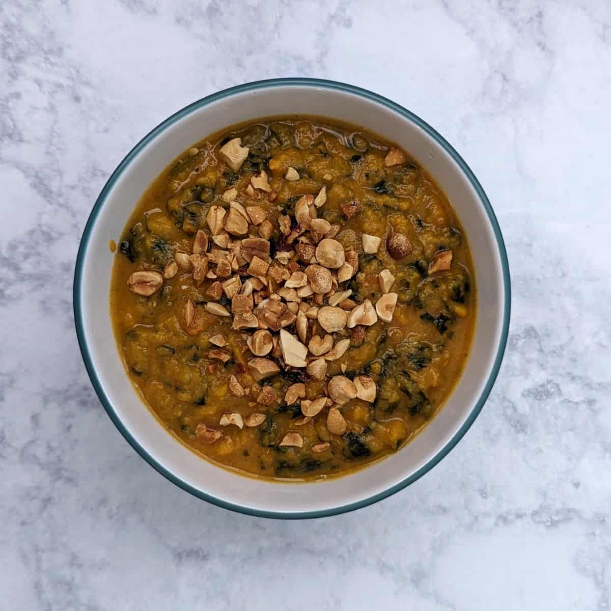 sweet potato peanut stew, in a bowl, topped with peanuts